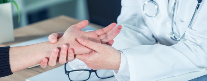 Orthopaedic surgeon looking at patient's hand